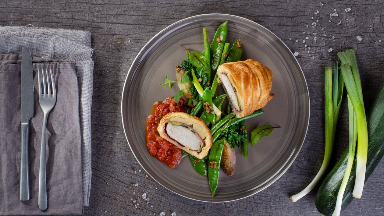 Kurczak w cieście francuskim z pikantnym sosem pomidorowo-paprykowym i glazurowanymi zielonymi warzywami – - Przepis
