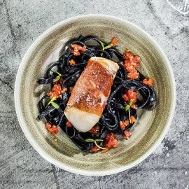 Dorsz z pomidorami concasse na czarnym Tagliatelle Dorsz z pomidorami concasse na czarnym Tagliatelle