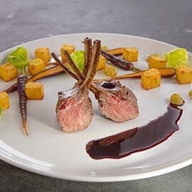 Comber jagnięcy podany z kremem z czerwonego wina i winogronami Comber jagnięcy podany z kremem z czerwonego wina i winogronami