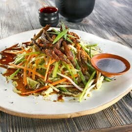 Sałatka z chrupkim mięsem kaczki, cebulą dymką i sosem sezamowo-sojowym Sałatka z chrupkim mięsem kaczki, cebulą dymką i sosem sezamowo-sojowym