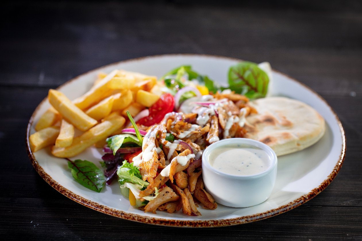Wegetariański kebab z pitą, warzywami, frytkami i sosem czosnkowym