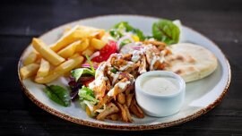 Wegetariański kebab z pitą, warzywami, frytkami i sosem czosnkowym